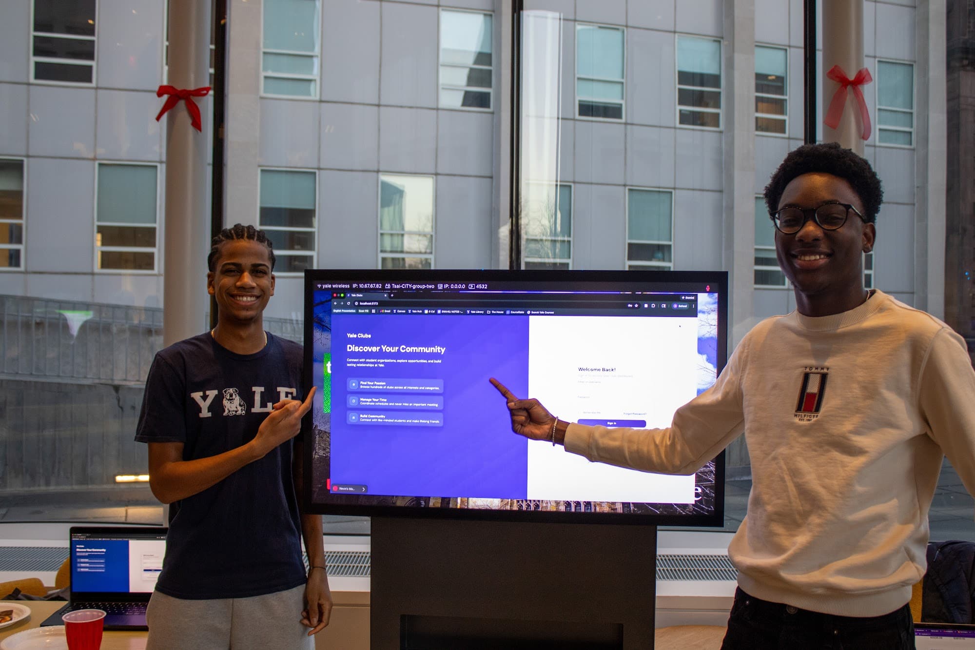 Two Catalyst members pointing at their project on a big screen