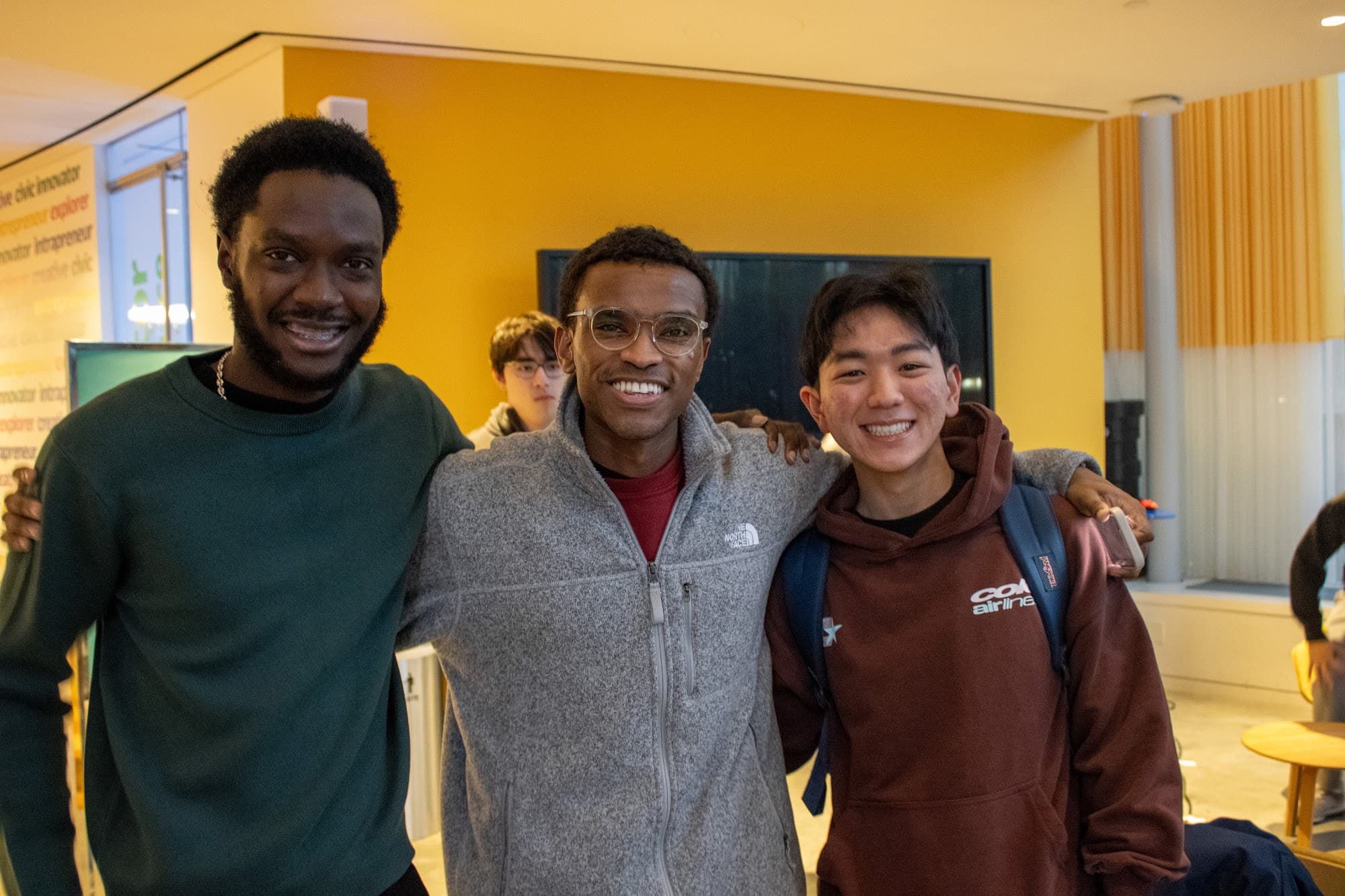Three dev team members smiling at a build night
