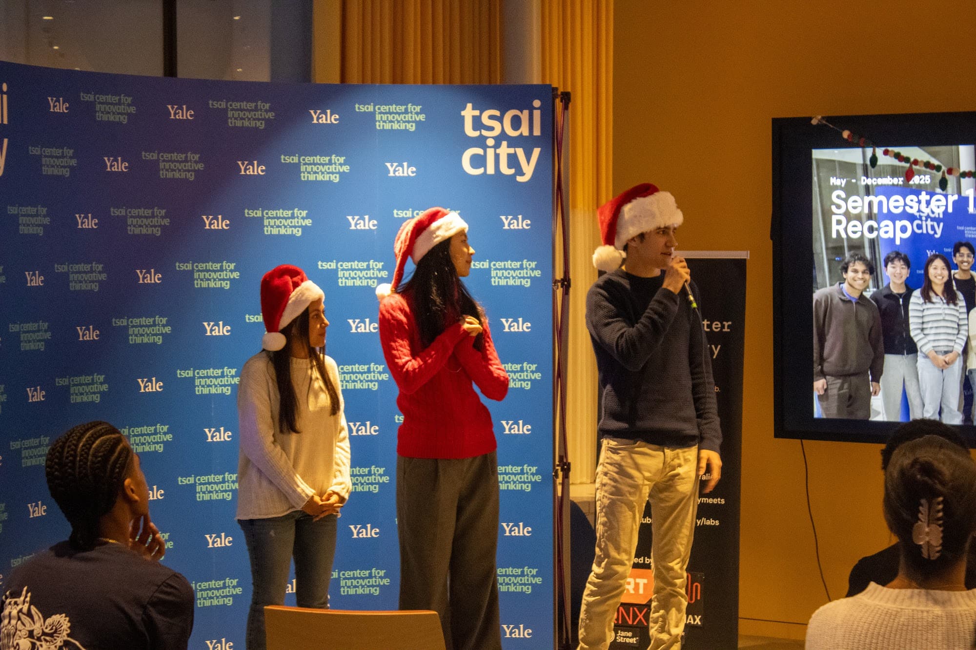 Hosts in Santa hats opening the holiday Demo Day