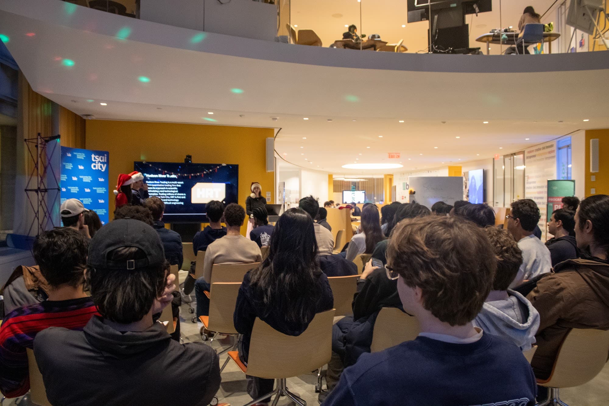 A packed room watching teams present at y/cs Demo Day