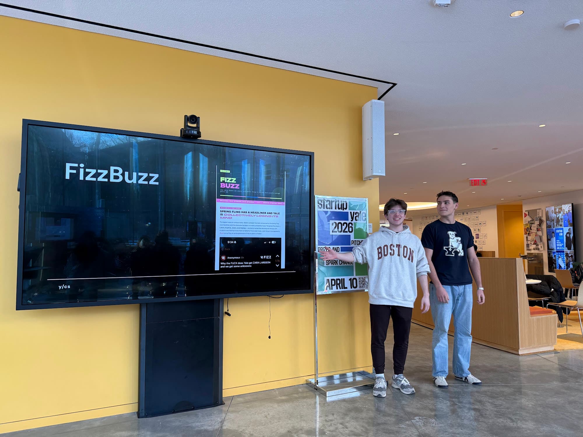 A hackathon team pitching their project on a big screen