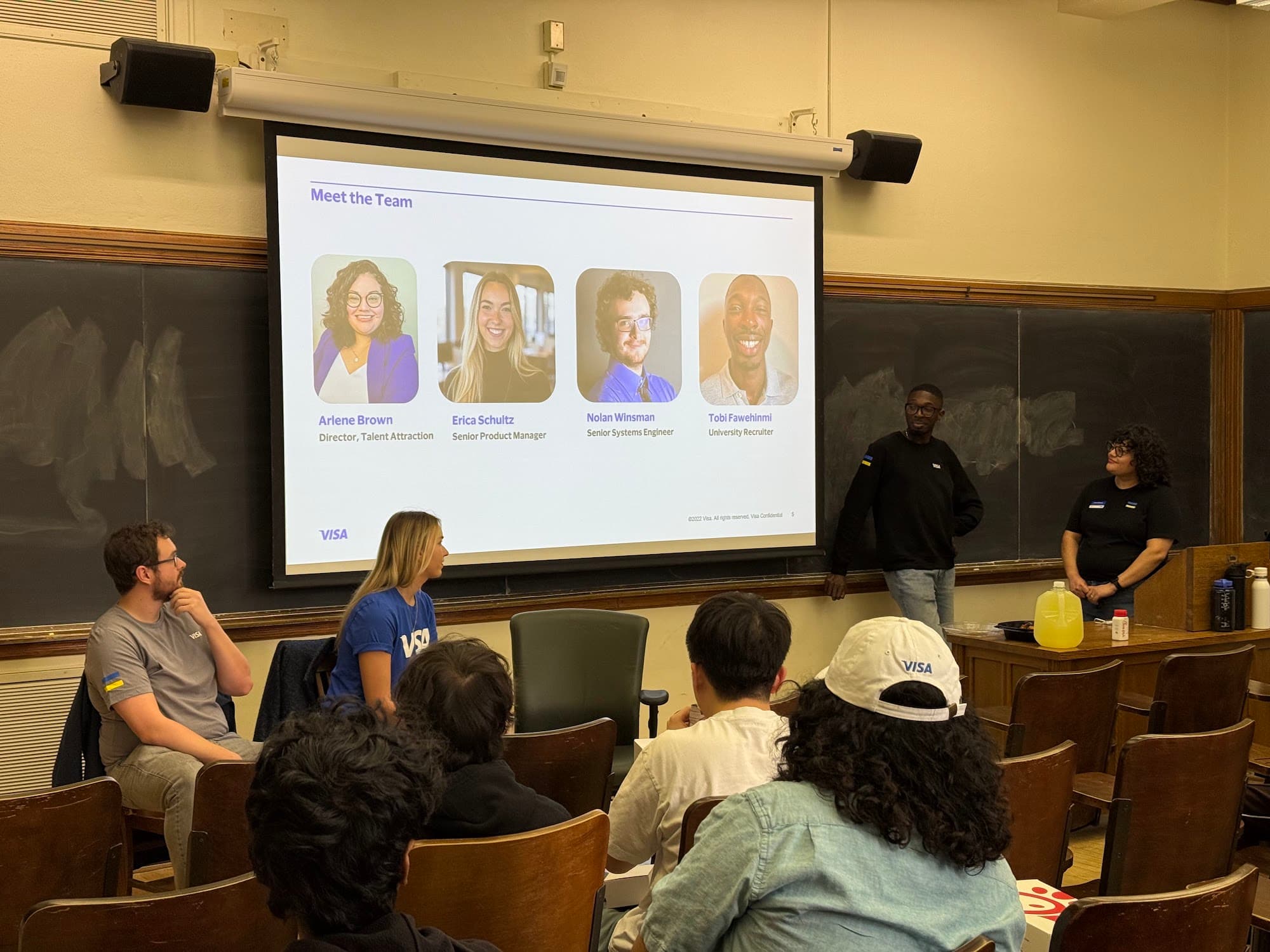 A sponsor panel presenting to students in a lecture hall