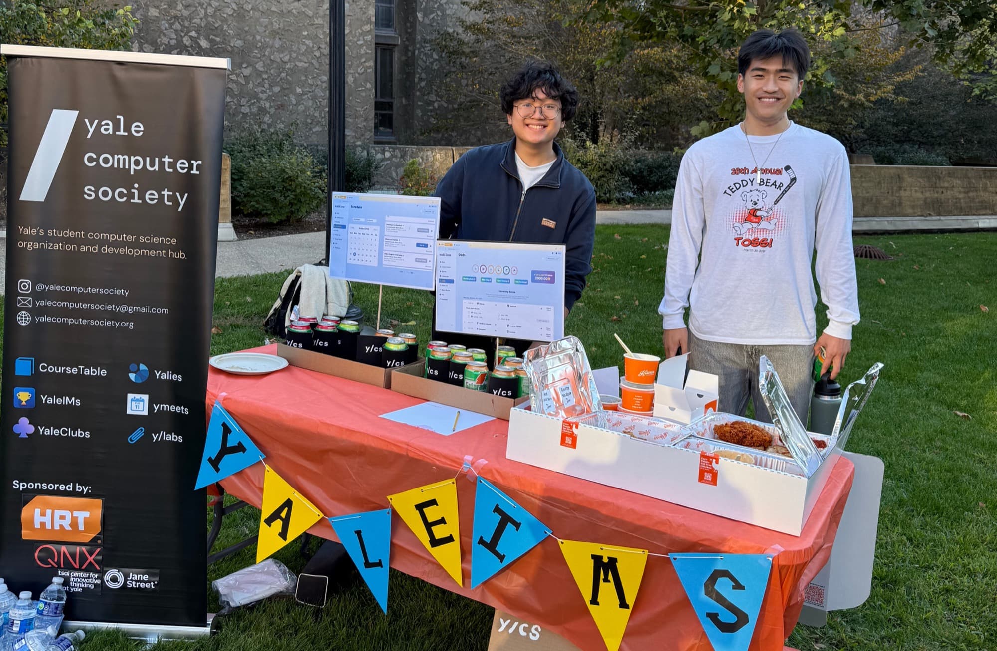 The y/cs launch booth on campus; its banner lists sponsors HRT, QNX, Tsai CITY and Jane Street